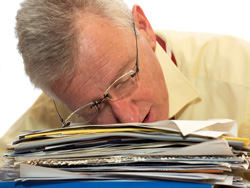 An exhausted senior businessman has fallen asleep on his work.